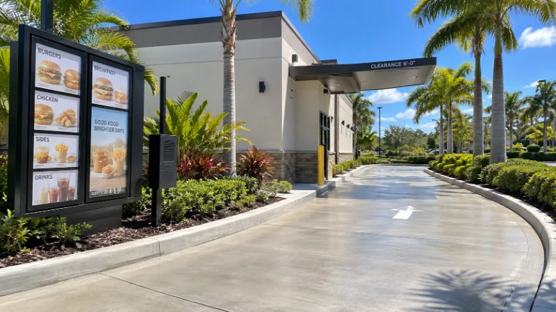 A drive-thru lane cleaned along the menu board and out under the clearance bar.